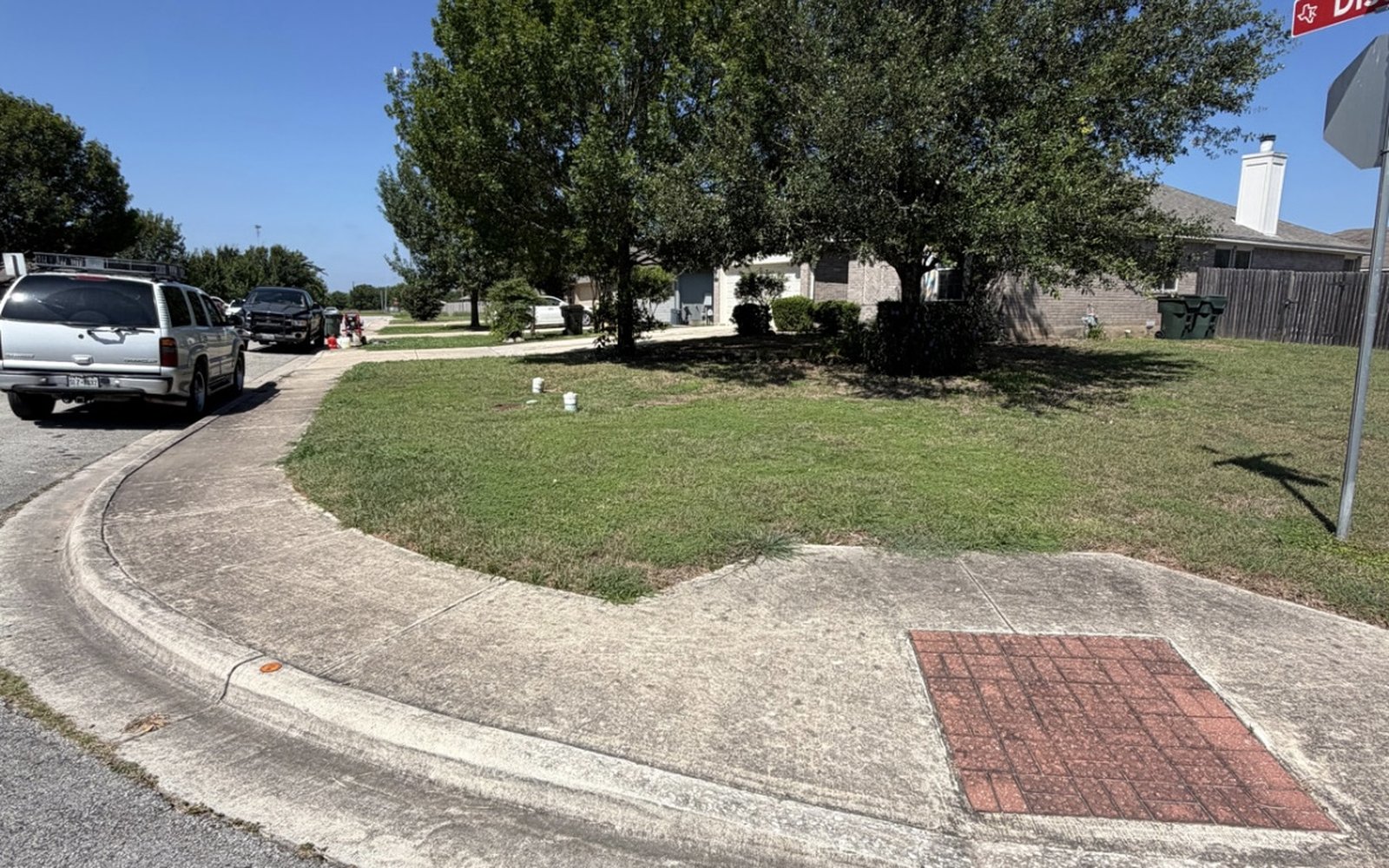 Neighborhood sidewalk and corner crosswalk pad in the Austin TX area stained grey before pressure washing